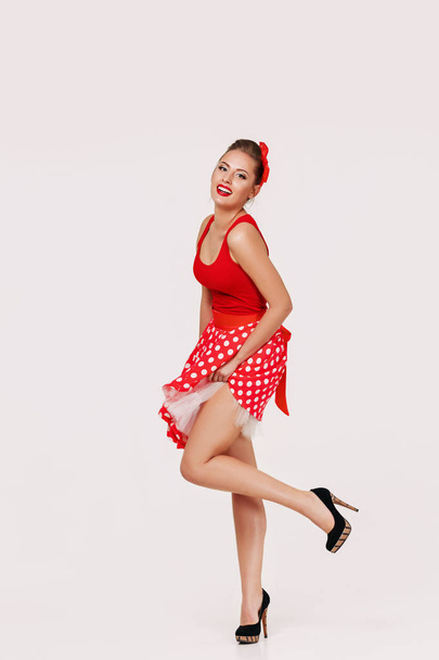 smiling pin up woman in polka dot red dress - Foto, imagen