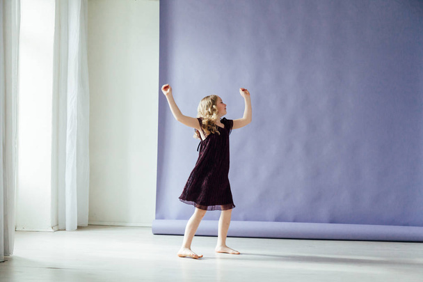 Girl in black dress dances alone to music - Valokuva, kuva