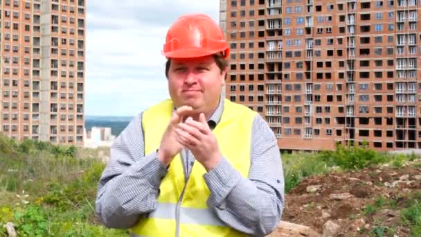 Male builder foreman, worker or architect on construction building site is clapping and looking to camera - Imágenes, Vídeo