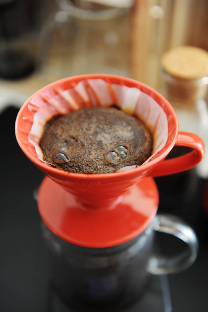 Coffee brewing process. Red ceramic dripper close up. Blooming. Specialty concept - 写真・画像