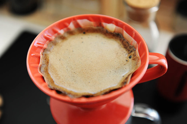 Kávéfőzés. Vörös kerámia Cseppszámláló közelről. Virágzó. Speciális koncepció - Fotó, kép