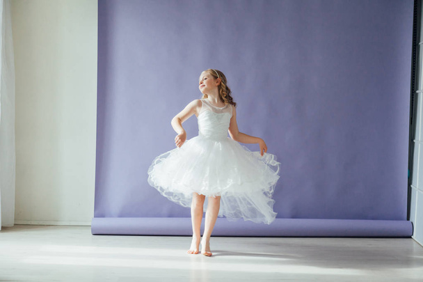Ragazza in abito bianco balla da sola in studio
 - Foto, immagini