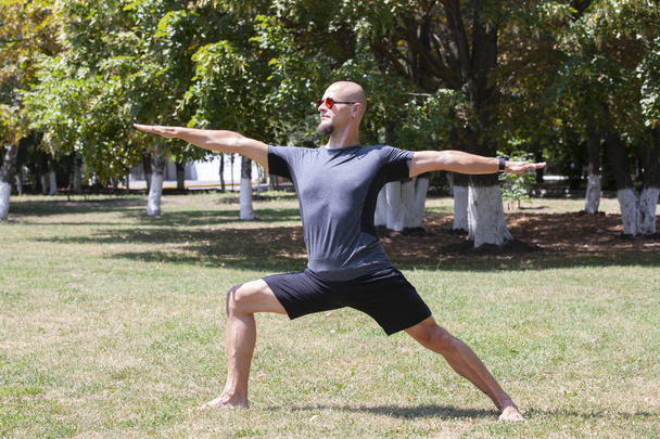 Man exercising in park. Smiling caucasian male doing core workout on grass. - Foto, Imagen