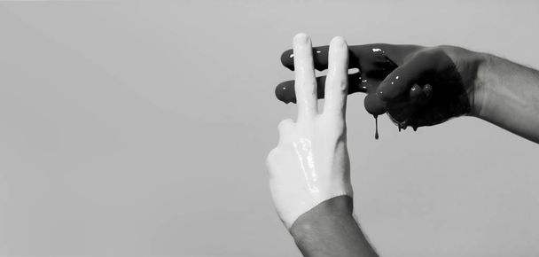 黒と白の男性の手がスタジオの背景にあるハッシュタグの記号で交差し、創造的な広告、ソーシャルネットワークの概念 - 写真・画像