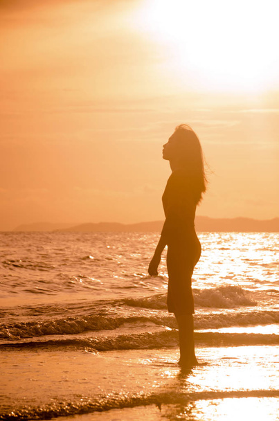beautiful young slim girl standing on sandy beach. - Foto, imagen