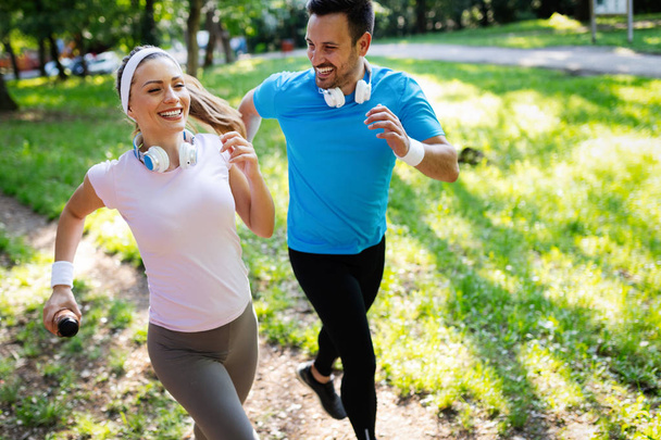 Couple jogging and running outdoors in nature, exercising together - Photo, Image