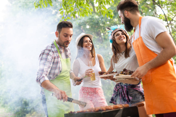 Friends having a barbecue party in nature while having fun - 写真・画像