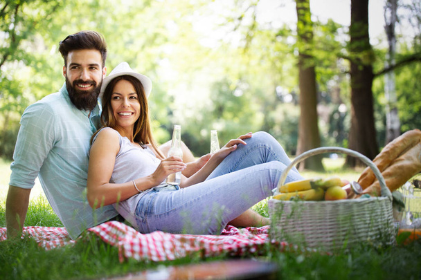 Happy couple in love enjoying picnic time outdoors - Fotó, kép