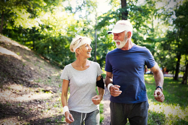 Beautiful sporty senior couple staying fit with running and jogging - Foto, imagen