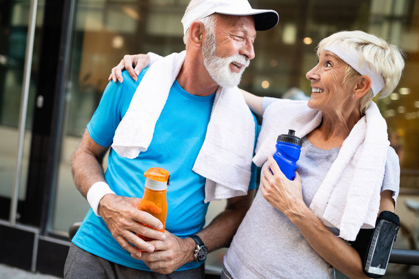 Senior couple drinks water to replenish energy and to hydrate - Foto, Imagen