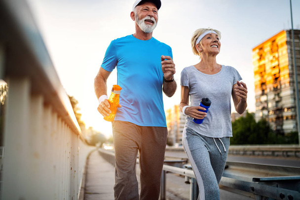 Senior couple is doing sport outdoors. Healthy lifestyle concept - Zdjęcie, obraz