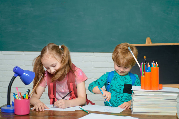 Back to school and happy time. Kid is learning in class on background of blackboard. Cute little preschool kid boy with Little child girl in a classroom. - Foto, Bild