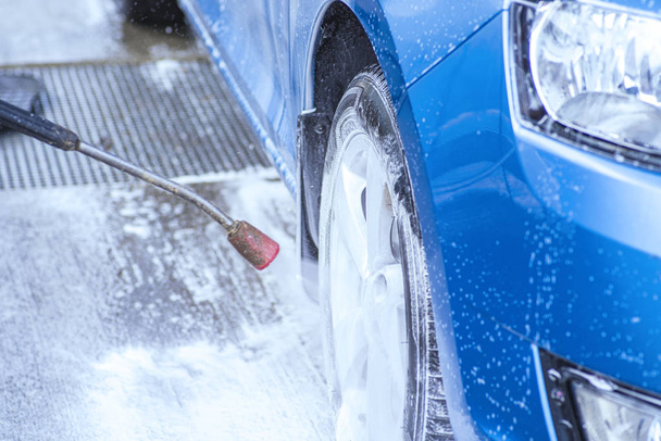 Lavagem de carro manual com água pressurizada no lado de fora da lavagem de carro.Limpeza de carro usando água de alta pressão
. - Foto, Imagem
