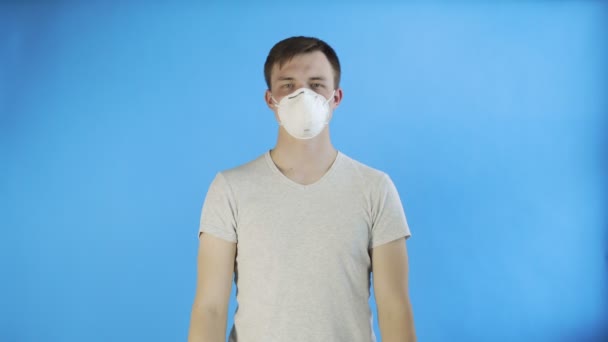 Fiatal férfi aktivista maszk az arcon, és a Think Planet poszter kék háttér - Felvétel, videó