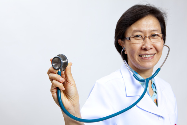 Smiling mature female medical doctor with stethoscope. - Фото, зображення