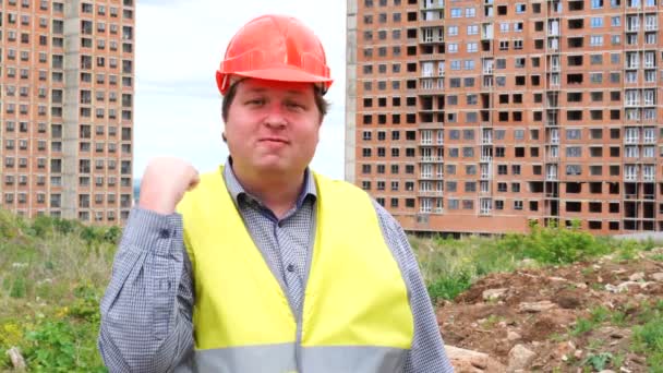 Male builder foreman, worker or architect on construction building site threatening his fist - Felvétel, videó