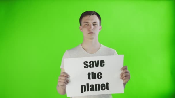 Νεαρός ακτιβιστής άνδρας με εκτός από την αφίσα πλανητών στο βασικό υπόβαθρο chroma - Πλάνα, βίντεο