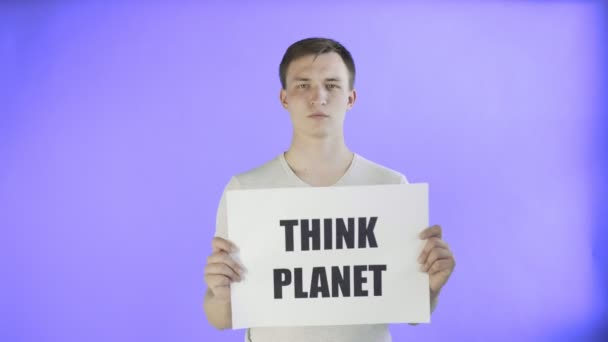 Νεαρός ακτιβιστής με Think Planet Poster στο φόντο Violet - Πλάνα, βίντεο