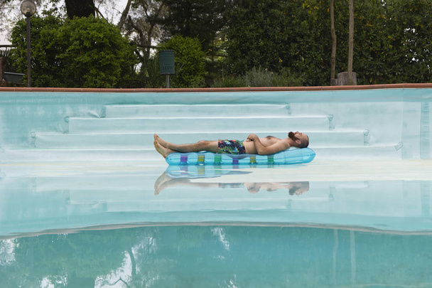 Swimming Pool with a Air mattress and a man body - Photo, Image