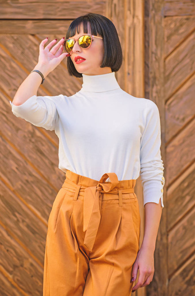 Girl with makeup posing in fashionable clothes. Fashionable outfit slim tall lady. Woman walk in elegant outfit. Fashion and style concept. Woman fashionable brunette stand outdoors wooden background - Photo, Image