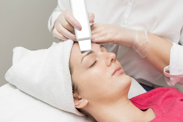 Cuidado de la piel. esteticista aplicando mascarilla de aceite de belleza en la cara usando cepillo En el salón de spa - Foto, imagen