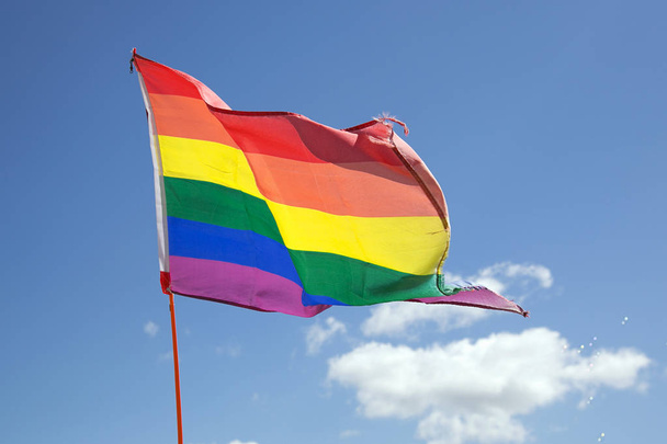 Rainbow Flag in una Gay Pride Parade appesa in una giornata di sole con uno sfondo blu cielo a sostegno della diversità e stili di vita alternativi nella comunità
. - Foto, immagini