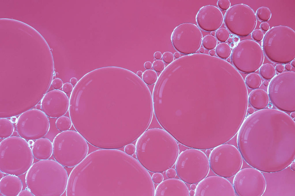 Macro of oil and water bubbles creating a scientific image of cell and cell membrane with a pink gradient and in a horizontal format. - Photo, Image