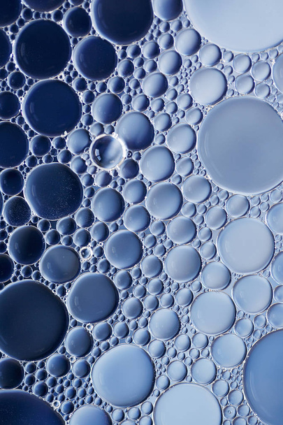Macro de burbujas de aceite y agua creando una imagen científica de la célula y la membrana celular con un gradiente azul y blanco y en un formato horizontal
. - Foto, Imagen