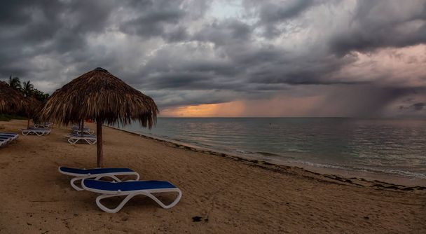 Bulutlu ve yağmurlu gün doğumu sırasında Triniday, Küba'da Karayip Denizi'nde kumlu bir plaj, Playa Ancon, güzel Panoramik görünümü. - Fotoğraf, Görsel