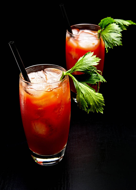 Bloody Mary cocktails with ice cubes and celery isolated on black - Φωτογραφία, εικόνα