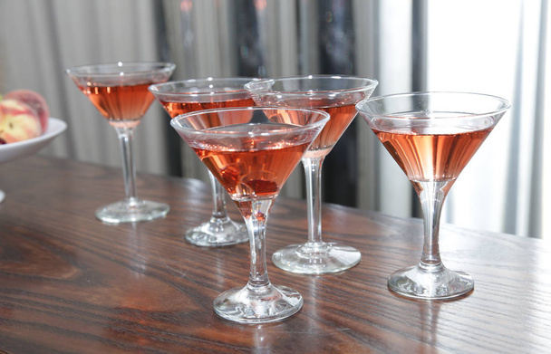 bicchieri di martini di cocktail di vino rosso su un tavolo di legno di un bar su uno sfondo d'argento
 - Foto, immagini