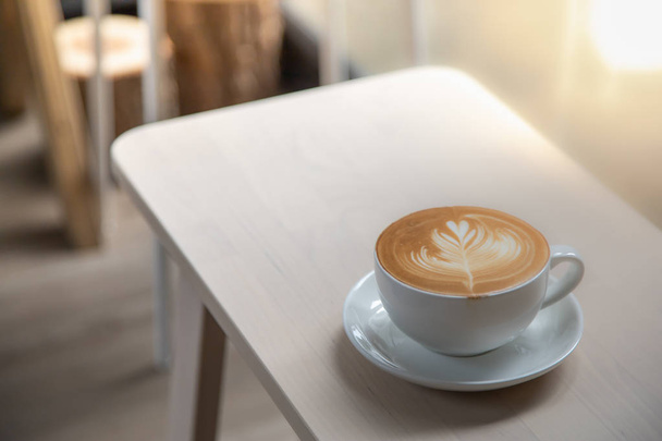 Закрыть белую чашку горячего кофе латте с молочной пеной сердце
 - Фото, изображение