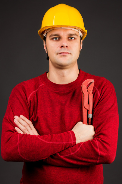 Portrait of a young worker holding pliers - Fotoğraf, Görsel