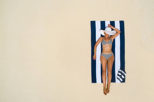 Summer holiday fashion concept - tanning girl wearing sun hat at - Fotografie, Obrázek