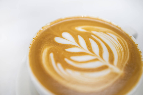 Zbliżenie białej filiżanki gorącej kawy latte z sercem pianki mlecznej - Zdjęcie, obraz