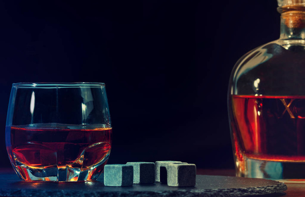 Glass of cognac, grey stones and bottle of XO - Фото, изображение