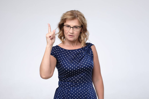 Mature business woman wearing glasses pointing with finger up - Photo, Image