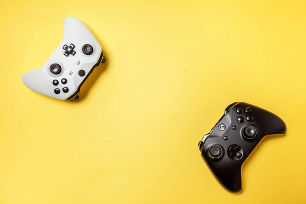 Bianco e nero due joystick su sfondo giallo. Concorso di gioco per computer concetto di confronto di controllo videogame
 - Foto, immagini
