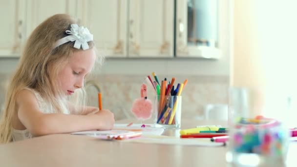 Jolie petite fille assise à la table et dessine avec des crayons
. - Séquence, vidéo