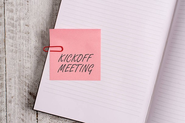 Writing note showing Kickoff Meeting. Business photo showcasing Special discussion on the legalities involved in the project Notebook stationary placed above classic wooden backdrop. - Photo, Image