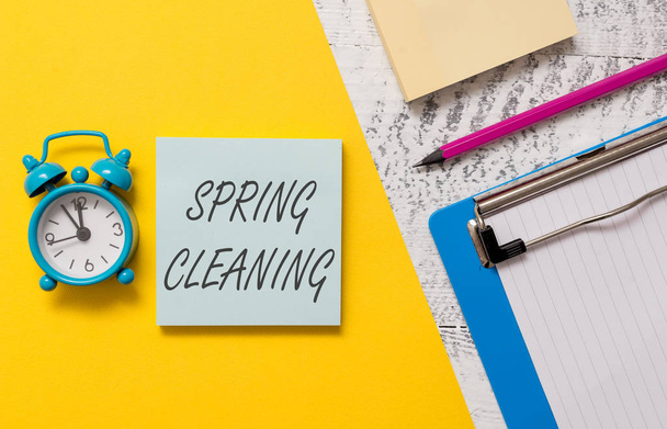 Word writing text Spring Cleaning. Business concept for practice of thoroughly cleaning house in the springtime Notepads clipboard colored paper sheet marker alarm clock wooden background. - Photo, image