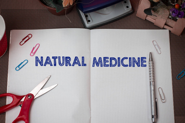 Writing note showing Natural Medicine. Business photo showcasing any of various systems of healing or treating disease Scissors and writing equipments plus math book above textured backdrop. - Photo, Image