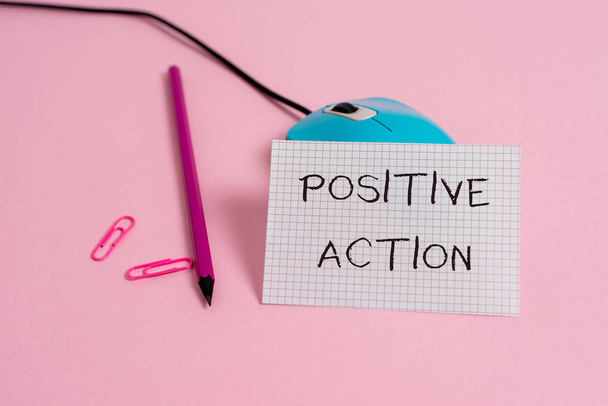Word writing text Positive Action. Business concept for doing good attitude against certain situation Fine reaction Wire vintage mouse clips marker squared paper sheet colored background. - Photo, Image