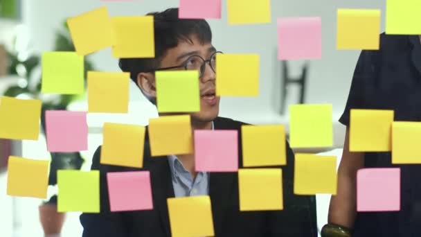 Groep van Aziatische creatieve mannen workshop en Brainstorm voor spiegel bord. Young Professional Business team werken strategie, bedrijfssituatie, Startup in Loft Office concept. Slow Motion. - Video