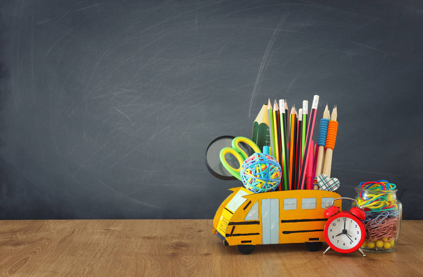 educación y vuelta al concepto escolar. lápices de pie como autobús sobre escritorio de madera frente a la pizarra del aula
 - Foto, Imagen