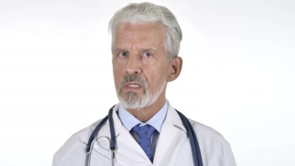 Retrato del médico mayor sacudiendo la cabeza para rechazar, fondo blanco
 - Imágenes, Vídeo