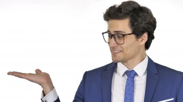 Jonge zakenman die product aan de zijkant toont, witte achtergrond - Video