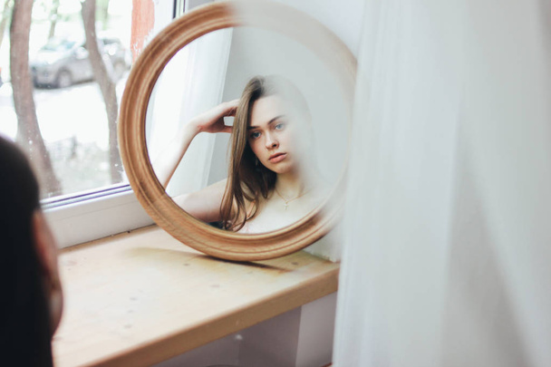 Sensual young beautiful long hair girl fashion model  in front of round mirror, soft focus - Photo, Image