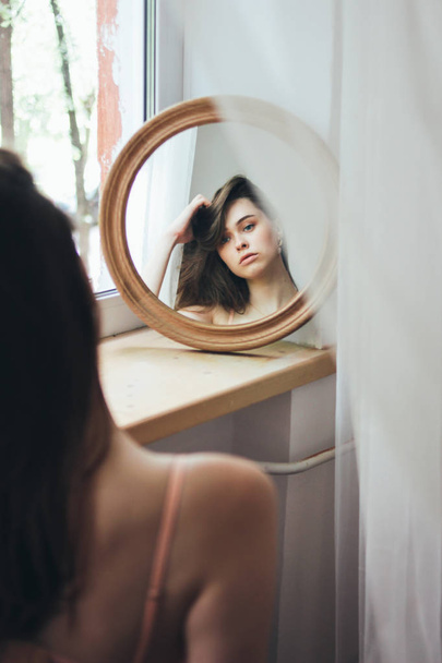 Sensual young beautiful long hair girl fashion model in front of round mirror, soft focus, high iso - Fotoğraf, Görsel