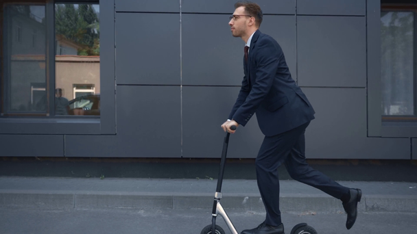 homme d'affaires en tenue formelle équitation kick scooter près du bâtiment
 - Séquence, vidéo